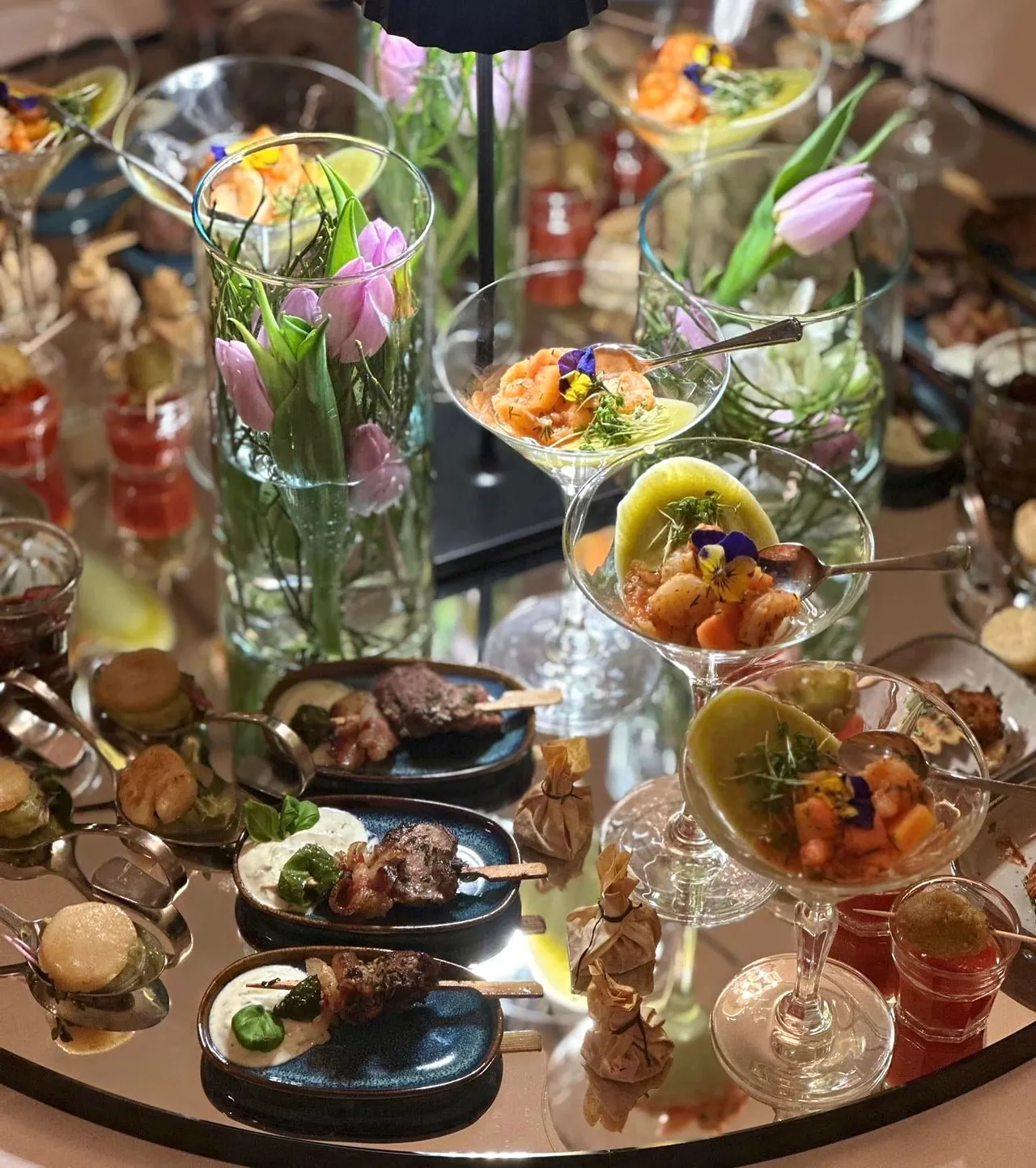 Fingerfood-Arrangement mit Blumen und kleinen Speisen