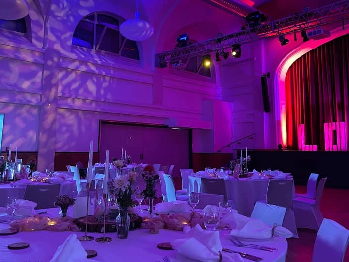 Festsaal mit pink-violetter Lichttechnik und Love-Schriftzug